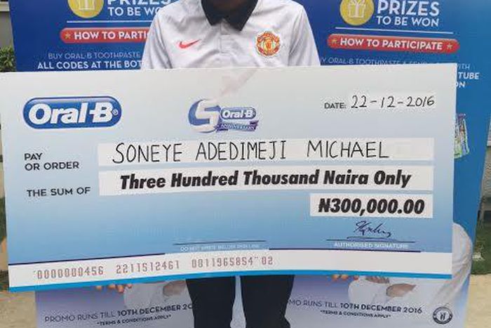 Soneye Adedimeji Michael Grand Prize Winner of the Oral B National Consumer Promo, with his cheque of N300,000.