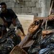 A worker arranges bodies in various stages of decomposition at the morgue of Henry's Funeral Homes in Manila