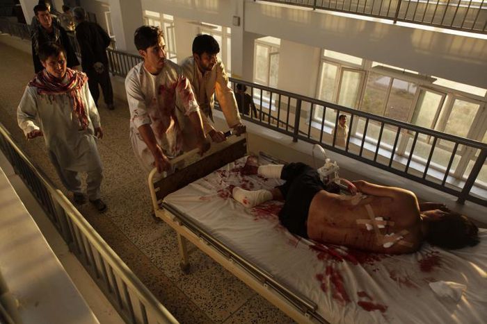 Afghan men carry a wounded man at a hospital after a bomb blast in northern Mazar-i-Sharif, Afghanistan October 12, 2016.