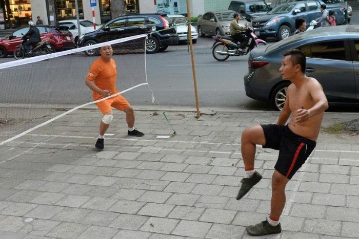 In Hanoi, Vietnam's traditional da cau or "foot badminton" is often played on the street where it competes for space with other activities