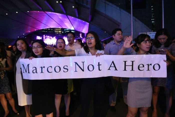 Protesters demonstrate in Manila following the burial of the late dictator Ferdinand Marcos in a secretive ceremony at the national heroes' cemetery