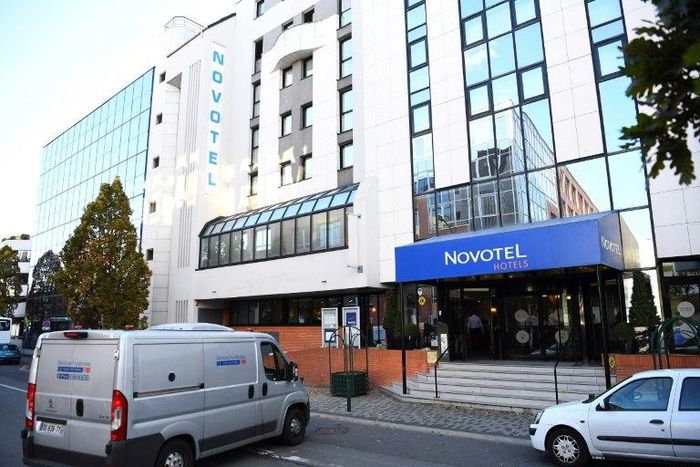 Vehicles are parked in front of the hotel where Munster head coach Anthony Foley was found dead on October 16, 2016 in Suresnes, outside Paris