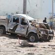 A policeman gives instructions near the wreckage of a car destroyed during a suicide bombing near the African Union's main peacekeeping base in Mogadishu, Somalia, July 26, 2016. REUTERS/Ismail Taxta