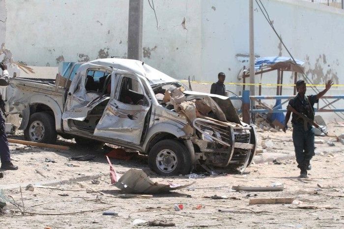 A policeman gives instructions near the wreckage of a car destroyed during a suicide bombing near the African Union's main peacekeeping base in Mogadishu, Somalia, July 26, 2016. REUTERS/Ismail Taxta