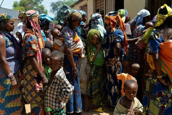 Women and children wait in line in the Begoua district, northeast of Bangui, to receive humanitarian and medical aid in 2014