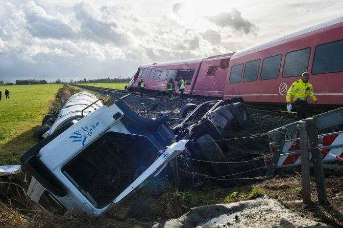 A policeman walks past the wreckage of a derailed passenger train and a smashed milk tanker after a crash near Winsum, northeast Netherlands on November 18, 2016