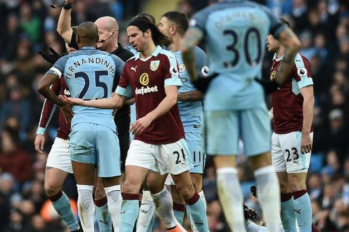 Referee Lee Mason (2L) shows a red card to Manchester City's midfielder Fernandinho during the English Premier League football match between Manchester City and Burnley at the Etihad Stadium in Manchester, north west England, on January 2, 2017
