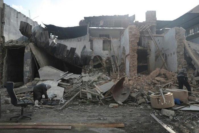 Syrian men inspect the rubble of a destroyed house in the rebel-held town of Douma, on the eastern outskirts of Damascus, on December 30, 2016