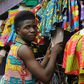 A tailor prepares clothes to sell at an African clothes shop in Monrovia