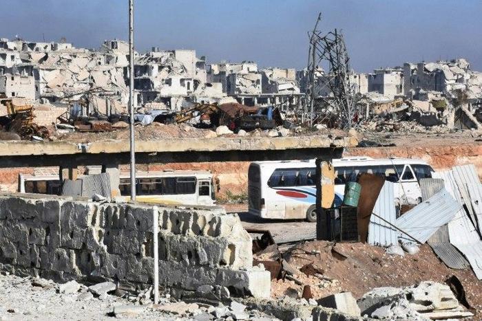 Buses to evacuate Syrians from eastern Aleppo enter the city through the Ramoussa crossing on December 20, 2016