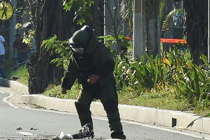 A police bomb disposal expert works to defuse a bomb found in a rubbish bin near the US embassy in Manila on November 28, 2016