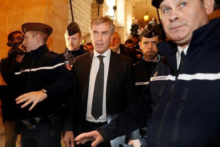 Gendarmes escort French former budget minister Jerome Cahuzac (C) as he leave the Paris courthouse following his tax fraud and money laundering trial's verdict on December 8, 2016