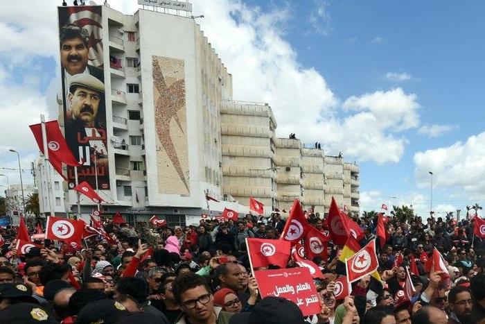 Tunisians wave their national flag during a march against terrorism outside Tunis' Bardo Museum on March 29, 2015