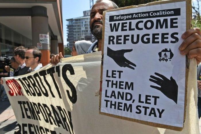 A protester holds up a placard opposing Australia's refugee policy
