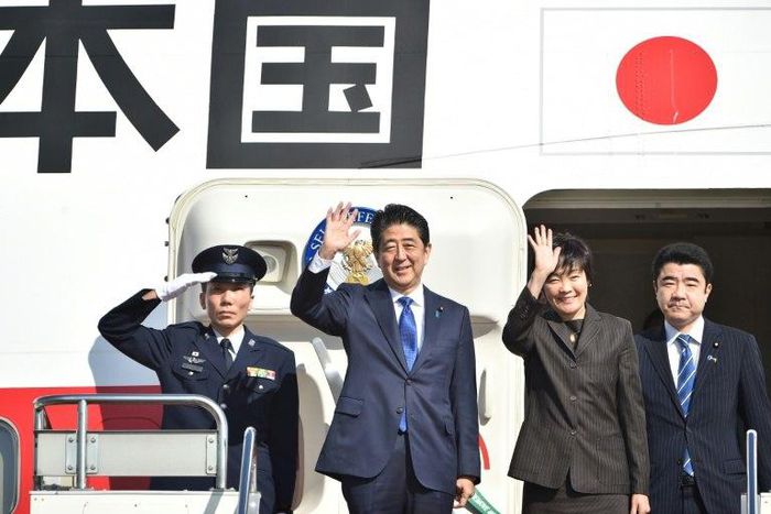 Japan's Prime Minister Shinzo Abe (2nd L) and his wife Akie wave to well-wishers prior to boarding a government plane at Tokyo's Haneda on November 17, 2016