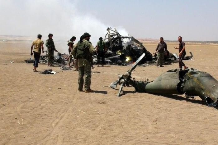 Syrian rebels look at the wreckage of a Russian military transport helicopter shot down between Idlib province, and neighbouring Aleppo