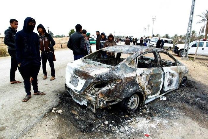 Security forces and locals gather at the site of an attack on a police checkpoint, near the town of Qadisiyah, 40km south of the holy Shiite Iraqi city of Najaf on January 1, 2017