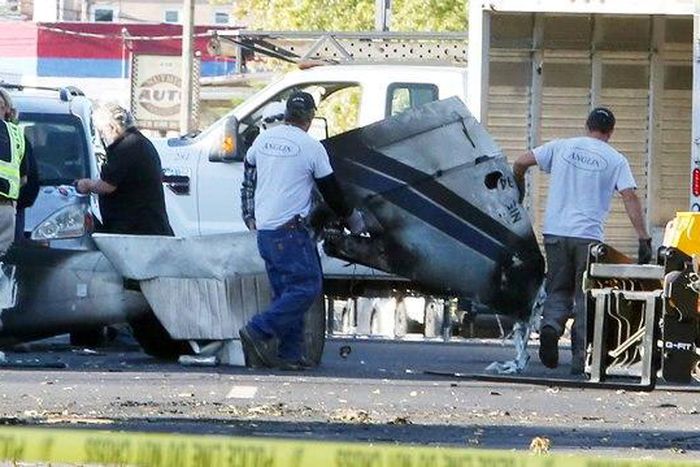 Wreckage is removed from the scene of a twin-engine plane that struck a utility pole and burst into flames in downtown East Hartford, Connecticut U.S., October 12, 2016.