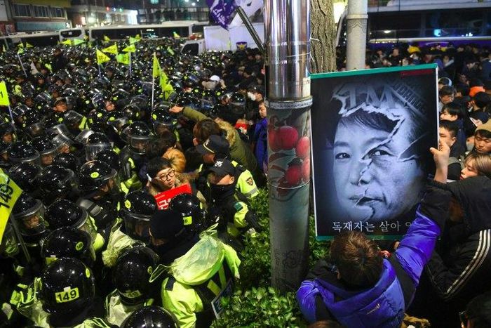 Riot police and protesters engage in a shoving match as the protesters attempt to march toward the presidential Blue House during an anti-government rally in Seoul