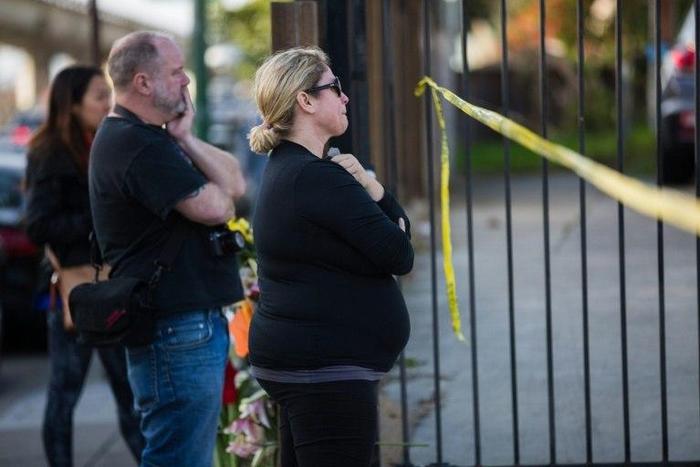 People mourn near the site of a devastating fire on December 4, 2016 in Oakland, California.