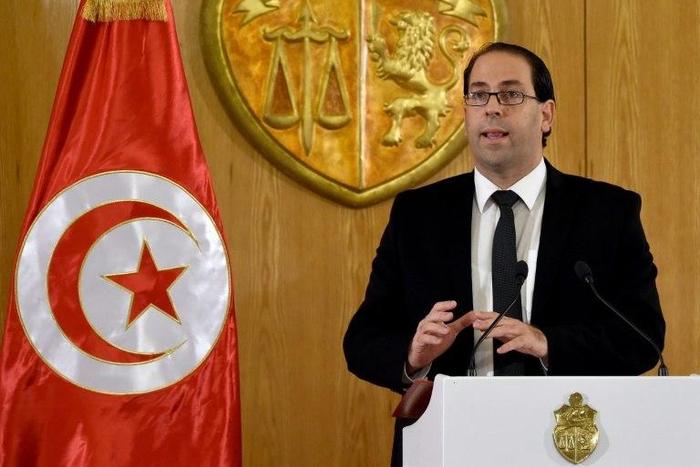 Tunisian Prime Minister Youssef Chahed, seen in August 2016, said the transition to democracy was costly for his country, which relies on France for help "at this critical moment"