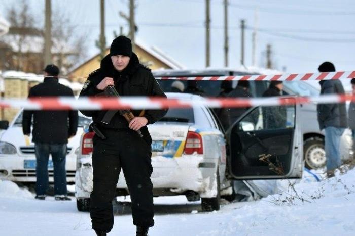 An armed policeman stands guard in the town of Knyazychy, about 30 kilometres east of Kiev, on December 4, 2016