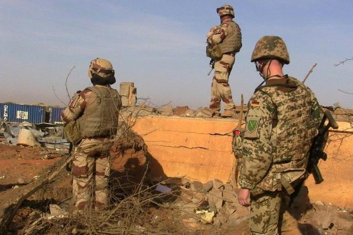 Soldiers of the Barhkane operation stand next to debris following a suicide car bomb attack at the airport of Gao on November 30, 2016