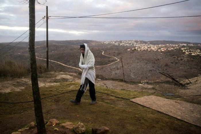 A young Israeli settler prays in the settlement outpost of Amona, in the Israeli-occupied West Bank