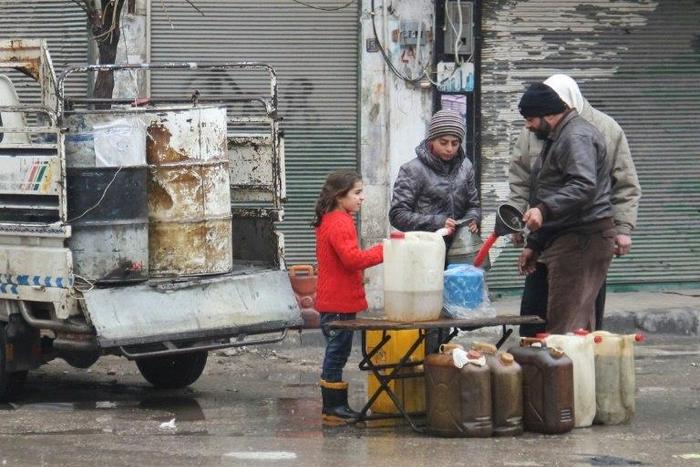 Residents buy petrol on a street in the northwestern Syrian city of Idlib on December 30, 2016 as a truce brokered by Russia and Turkey came into effect