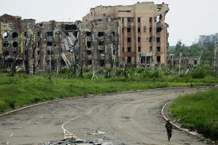 An armed pro-Russian separatist of the self-proclaimed Donetsk People's Republic walks in front of the destroyed Donetsk International Airport on June 1, 2016