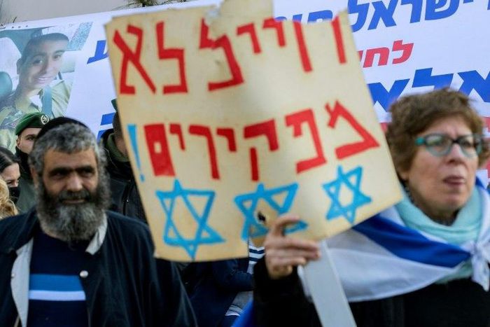 An Israeli woman holds a poster reading in Hebrew: "We never abandon soldiers" as she demonstrates outside the defence ministry in Tel Aviv on January 4, 2017, in support of Israeli soldier Elor Azaria, who shot dead a wounded Palestinian assailant