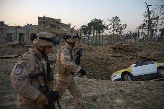 NATO soldiers walk past the site of an attack targeting the German consulate in Mazar-i-Sharif, Afghanistan on November 11, 2016