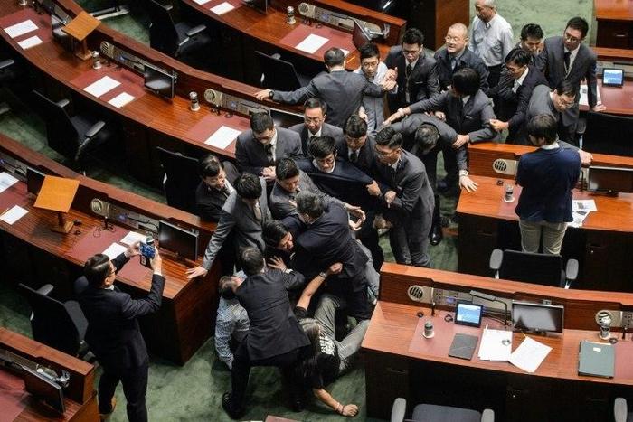 Newly elected lawmaker Baggio Leung (C in glasses) is restrained by security after attempting to read out his Legislative Council oath at Legco in Hong Kong on November 2, 2016