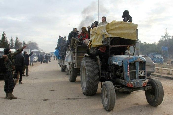 A tractor carrying people evacuated from rebel-held neighbourhoods of Aleppo arrives in opposition-controlled Khan al-Assal on December 16, 2016