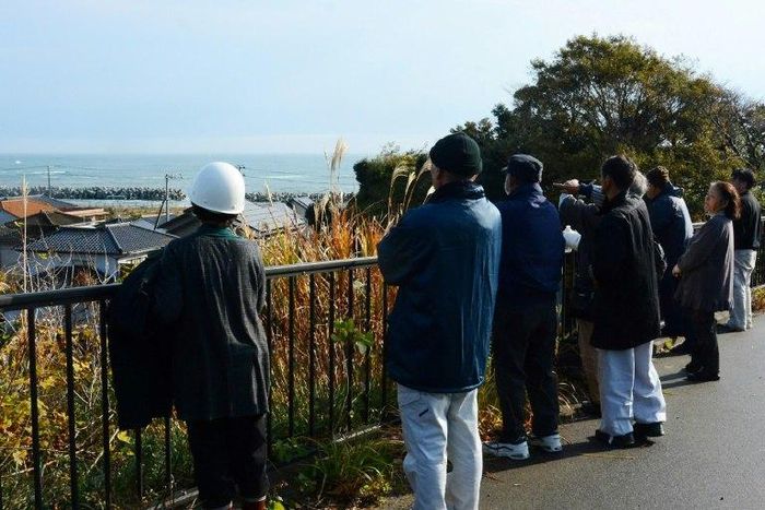 Local residents look out to sea from higher ground after evacuating their homes following a 6.9 magnitude earthquake and tsunami alert in Iwaki, Fukushima prefecture, on November 22, 2016