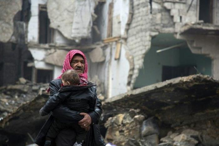 Syrians leave a rebel-held area of Aleppo towards the government-held side during an operation by Syrian government forces to retake the embattled city