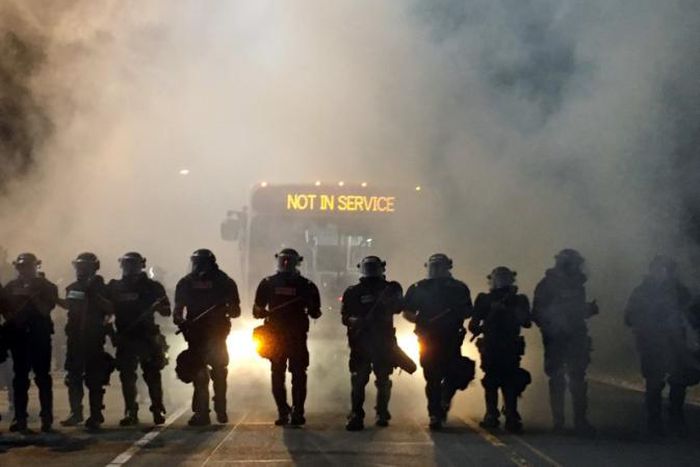Police officers wearing riot gear block a road during protests after police fatally shot Keith Lamont Scott in the parking lot of an apartment complex in Charlotte, North Carolina, U.S. September 20, 2016.