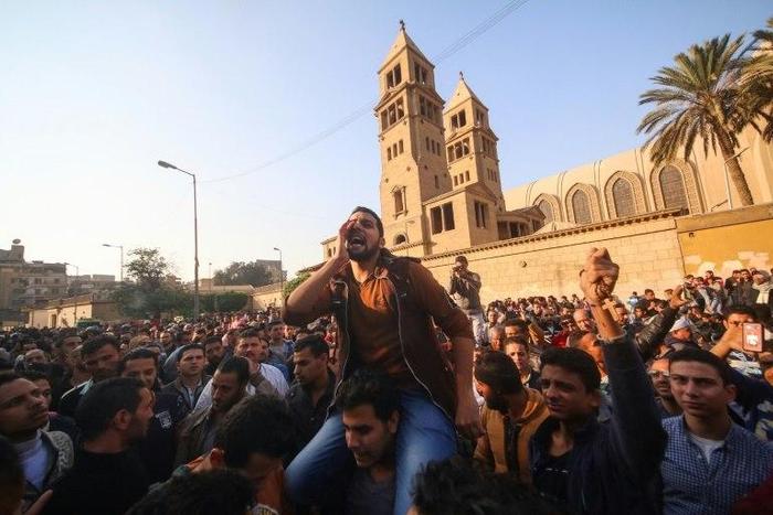 Egyptians gather outside the Saint Peter and Saint Paul Coptic Orthodox Church in Cairo on December 11, 2016