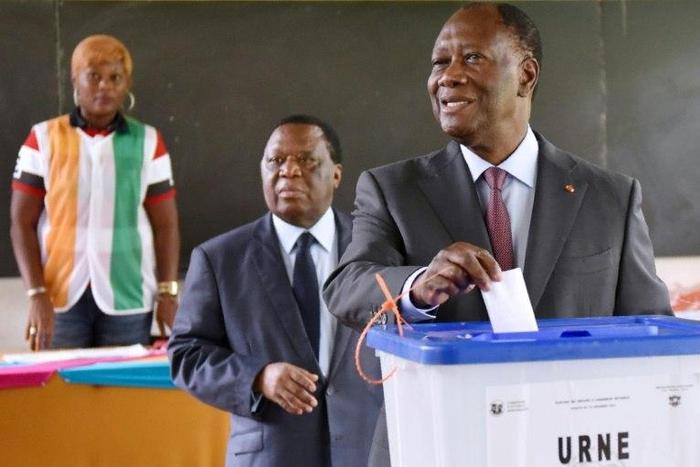 Ivory Coast's President Alassane Ouattara (R) casts his ballot into an urn next to the President of the Independent Election Commission (CEI) Youssouf Bakayoko (L) at a polling station in Cocody, a commune of Abidjan, on December 18, 2016