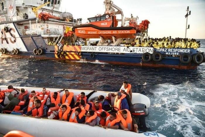 Maltese activists help migrants to board a small rescue boat during a rescue operation off the coast of Libya, on November 5, 2016