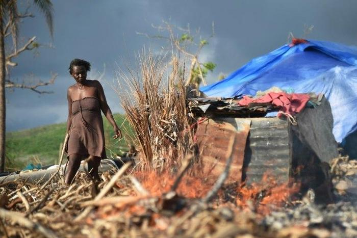 Marie walks next to her house damaged by Hurricane Matthew in the village of Labeyi, southwestern Haiti