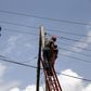 Power officials stand on ladders to fix electric cables along a road in Egbeda dstrict in Nigeria's commercial capital Lagos, July 1, 2015. Picture taken July 1, 2015. REUTERS/Akintunde Akinleye