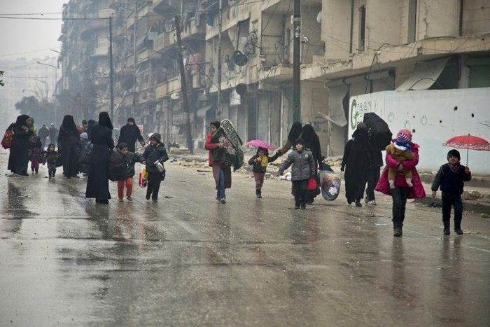People leave a rebel-held area of Aleppo towards the government-held side on December 13, 2016