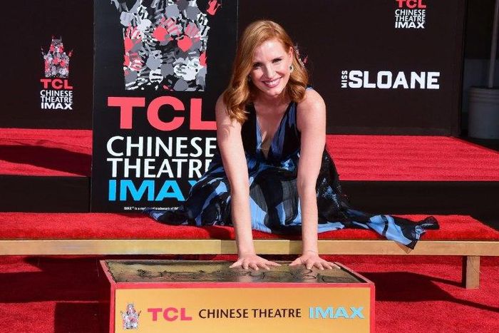 Actress Jessica Chastain smiles while imprinting her handprints in the block of cement at the TCL Chinese Theater in Hollywood, California on November 3, 2016