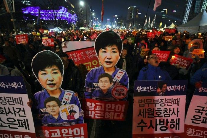 Protesters carry portraits of South Korea's President Park Geun-Hye during a protest demanding the impeached President resign immediately in Seoul on January 7, 2017