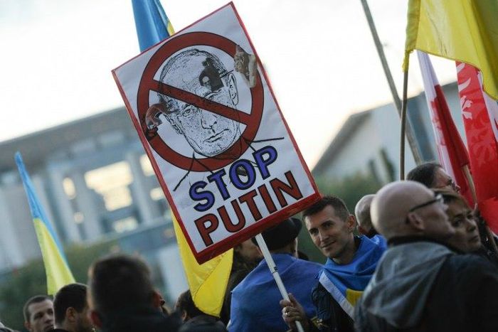 Protester demonstrate outsiude the chancellery in Berlin ahead of a meeting of leaders of Russia, Ukraine, France and Germany