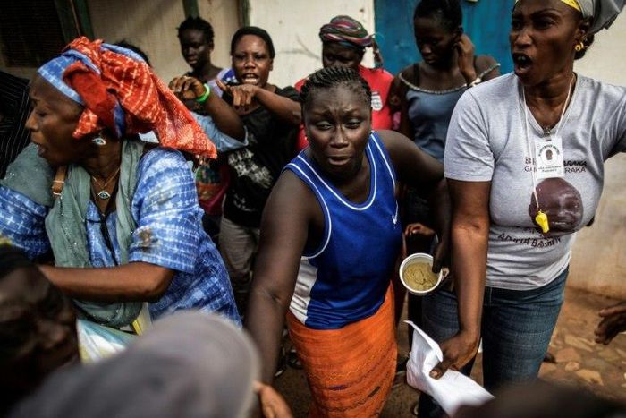 A woman (C) supportring the incumbent Gambian president Yahya Jammeh, quarrels with supporters of opposition leader Adama Barrow in Banjul