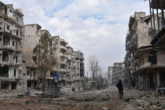 A member of the Syrian regime forces stands amidst destruction in the former rebel-held Sukkari district in the northern city of Aleppo on December 23, 2016