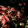 People light candles at a makeshift memorial in front of the Kaiser-Wilhelm-Gedaechtniskirche in Berlin, where a truck crashed the day before into a Christmas market