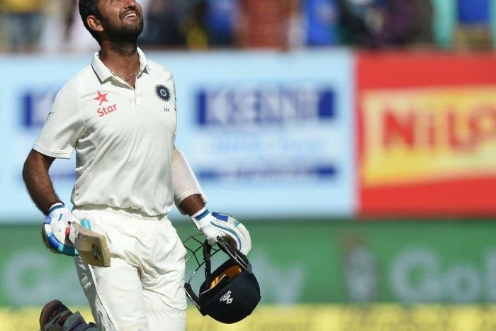 India's Cheteshwar Pujara celebrates after scoring a century on the third day of the first Test against England in Rajkot on November 11, 2016